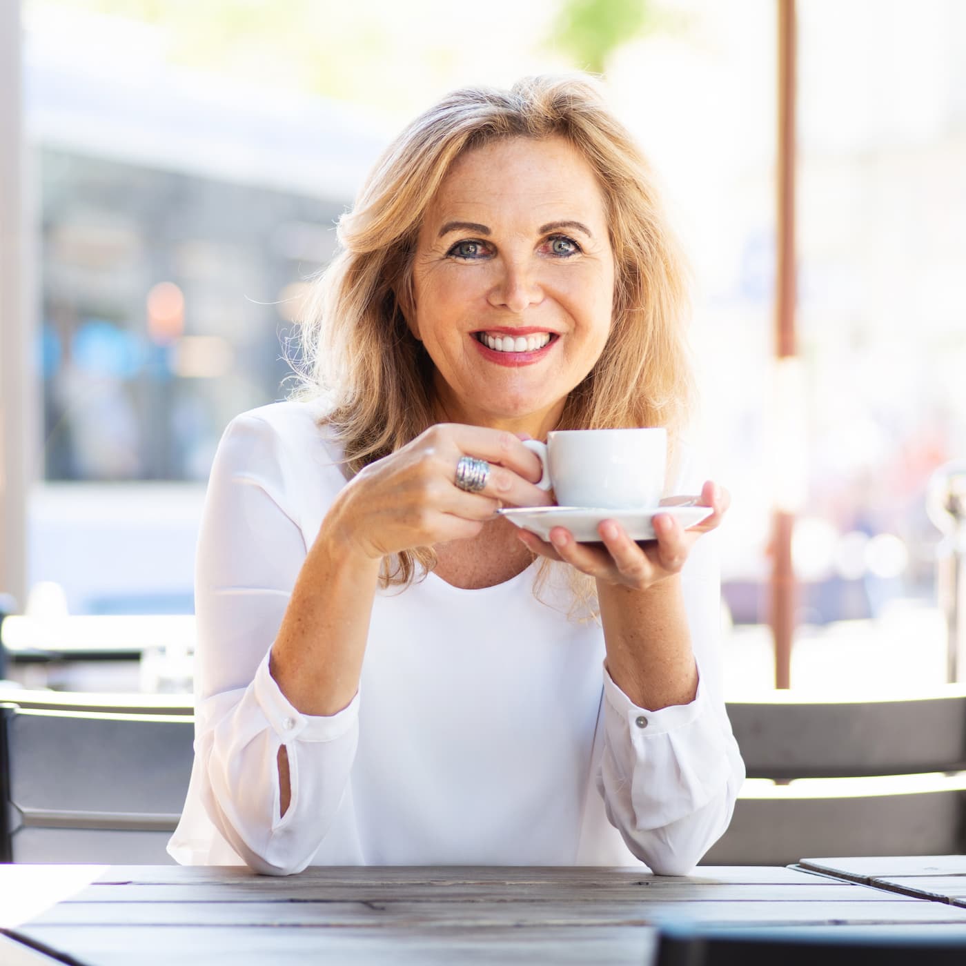 woman smiling whilst drinking her tea